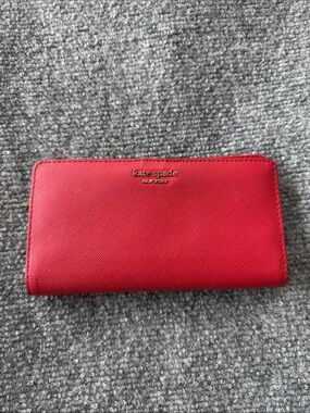 kate spade red Saffiano zip-around wallet with gold logo